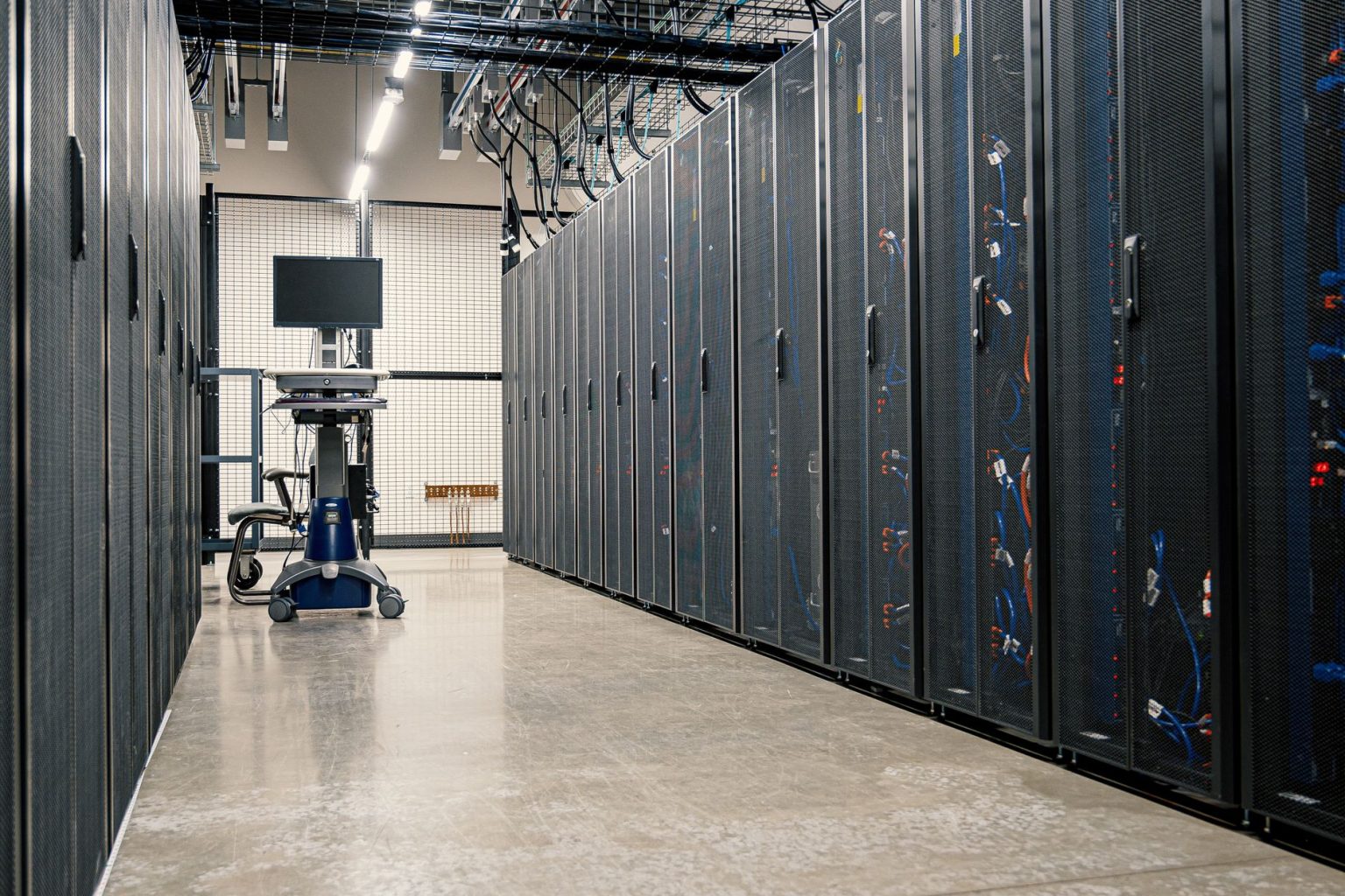 Armários metálicos com servidores, equipamentos de rede e cabeamento em um data center moderno