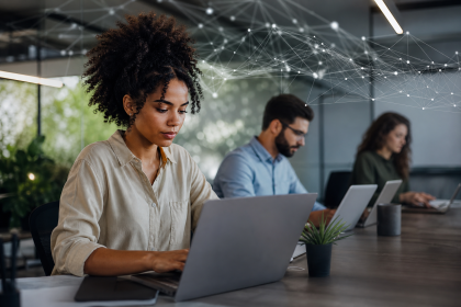 Equipe de uma pequena empresa de tecnologia trabalhando em soluções de inteligência artificial em um escritório moderno.