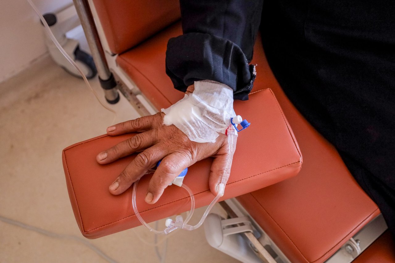 Close da mão de uma pessoa recebendo quimioterapia em uma unidade de saúde.