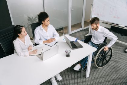 Grupo diverso de colegas participa de uma reunião de trabalho em um ambiente corporativo.