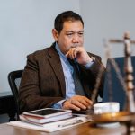 Juiz em um escritório jurídico usa um notebook enquanto analisa informações.